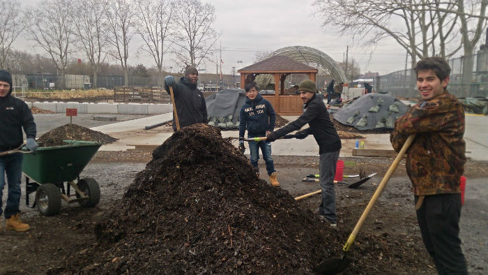 DURA Decathletes shoveling a large compost pile at Added Value Community Farm in Red Hook, December 2014