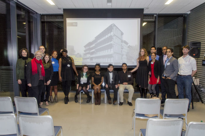 Team DURA and sponsors posing together at the Ecofest awards ceremony, in front of a rendering of the DURA house